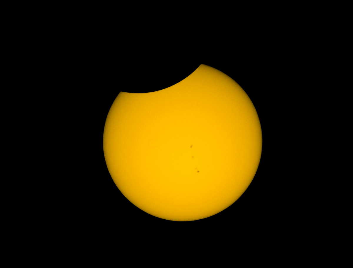 Der Mond zieht sich zurück. Schöne Fleckengruppe auf der Sonne. © Autor